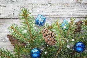 Christmas accessories in blue and fir branches on wooden background