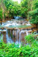 increíble cascada colorida en el bosque del parque nacional durante la primavera, hermoso bosque profundo en tailandia, larga exposición técnica, durante las vacaciones y el tiempo de relajación. foto