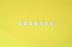 A few chewing gums lie on texture background of fashion pastel yellow color paper in minimal concept photo