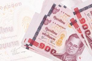 Los billetes de 100 baht tailandeses se encuentran apilados en el fondo de un gran billete semitransparente. presentación abstracta de la moneda nacional foto