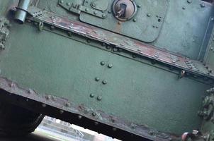 Texture of tank side wall, made of metal and reinforced with a multitude of bolts and rivets photo