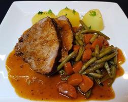 traditional german cuisine a beef pot roast  with vegetables and potatoes photo