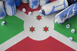 Burundi flag and few used aerosol spray cans for graffiti painting. Street art culture concept