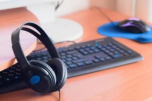 Big black headphones lie on the wooden desktop of the sound designer photo