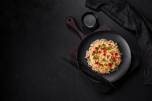 deliciosos fideos frescos con pimiento dulce, tomate, especias y hierbas foto