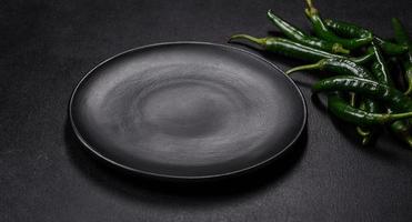 Hot pepper of green color on a dark concrete background photo