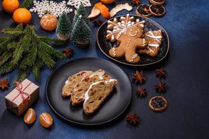 Delicious festive New Year's pie with candied fruits, marzipan and nuts on a dark concrete background photo