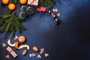 delicioso pastel festivo de año nuevo con frutas confitadas, mazapán y nueces sobre un fondo de hormigón oscuro foto