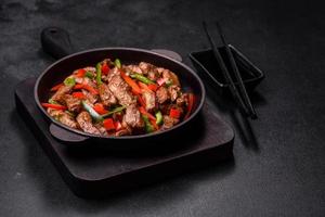 Delicious Asian teriyaki meat with red and green bell peppers photo