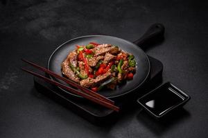 Delicious Asian teriyaki meat with red and green bell peppers photo