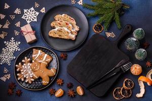 Delicious festive New Year's pie with candied fruits, marzipan and nuts on a dark concrete background photo