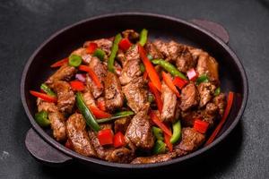 Delicious Asian teriyaki meat with red and green bell peppers photo