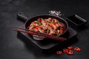 Delicious Asian teriyaki meat with red and green bell peppers photo