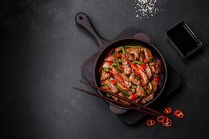 Delicious Asian teriyaki meat with red and green bell peppers photo