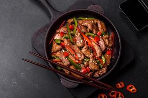 Delicious Asian teriyaki meat with red and green bell peppers photo
