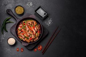 Delicious Asian teriyaki meat with red and green bell peppers photo