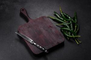 Hot pepper of green color on a dark concrete background photo