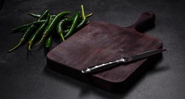 Hot pepper of green color on a dark concrete background photo