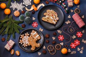 delicioso pastel festivo de año nuevo con frutas confitadas, mazapán y nueces sobre un fondo de hormigón oscuro foto