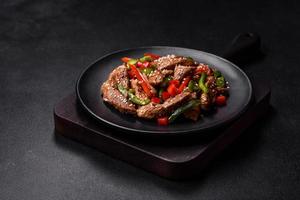 Delicious Asian teriyaki meat with red and green bell peppers photo