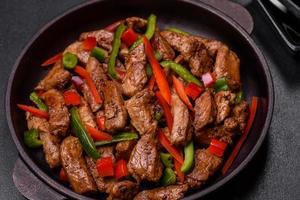 Delicious Asian teriyaki meat with red and green bell peppers photo