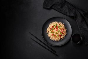 Delicious fresh noodles with sweet pepper, tomato, spices and herbs photo