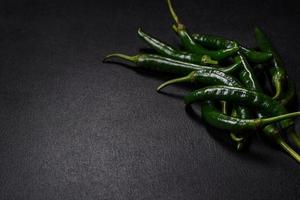 Hot pepper of green color on a dark concrete background photo