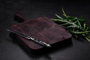 Hot pepper of green color on a dark concrete background photo
