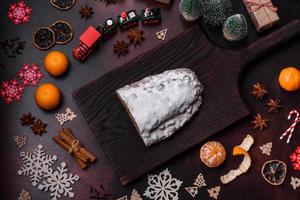 Christmas pie stollen with marzipan, berries and nuts on a dark concrete background photo