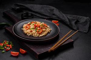 Delicious fresh noodles with sweet pepper, tomato, spices and herbs photo