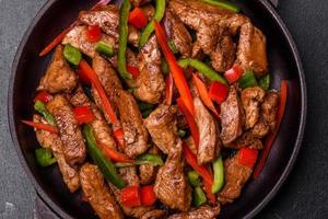 Delicious Asian teriyaki meat with red and green bell peppers photo