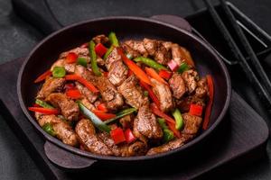 Delicious Asian teriyaki meat with red and green bell peppers photo