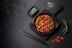 Delicious Asian teriyaki meat with red and green bell peppers photo