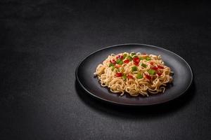 Delicious fresh noodles with sweet pepper, tomato, spices and herbs photo