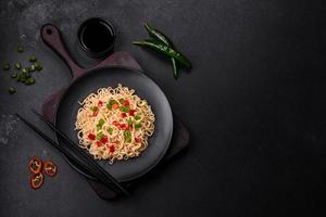 Delicious fresh noodles with sweet pepper, tomato, spices and herbs photo