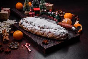 Christmas pie stollen with marzipan, berries and nuts on a dark concrete background photo