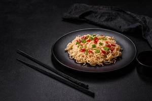 Delicious fresh noodles with sweet pepper, tomato, spices and herbs photo