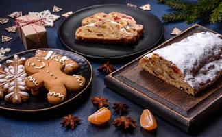 Delicious festive New Year's pie with candied fruits, marzipan and nuts on a dark concrete background photo