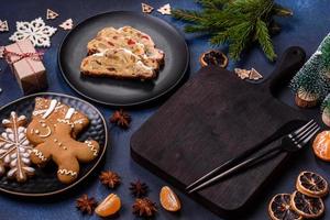 Delicious festive New Year's pie with candied fruits, marzipan and nuts on a dark concrete background photo
