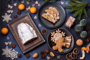 Delicious festive New Year's pie with candied fruits, marzipan and nuts on a dark concrete background photo