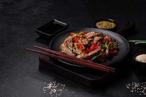 Delicious Asian teriyaki meat with red and green bell peppers photo