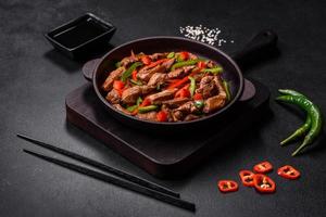 Delicious Asian teriyaki meat with red and green bell peppers photo