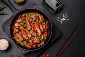 Delicious Asian teriyaki meat with red and green bell peppers photo