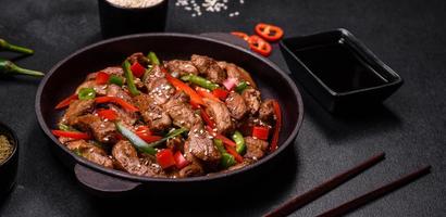 Delicious Asian teriyaki meat with red and green bell peppers photo