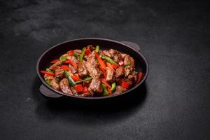 Delicious Asian teriyaki meat with red and green bell peppers photo