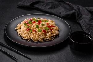Delicious fresh noodles with sweet pepper, tomato, spices and herbs photo