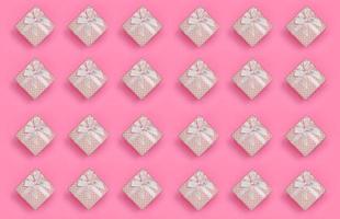 A lot of pink gift boxes lies on texture background of fashion pastel pink color paper in minimal concept. Abstract trendy pattern photo