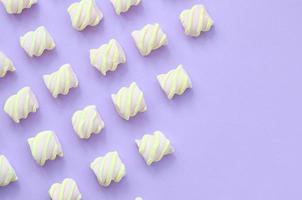 Colorful marshmallow laid out on violet paper background. pastel creative textures with copy space. minimal photo