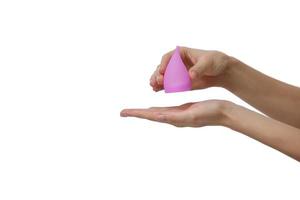 Pink menstrual cup. Close up of woman hand holding menstrual cup over white background. Women health concept, zero waste alternatives photo