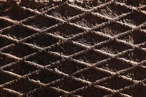 Canal cover surface texture. Rusty iron square pattern. Rusty metal square texture. Robust old iron rusted canal cover wallpaper. Ruststained canal grid form cover backdrop. photo